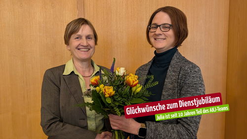 Fr. Dr. Maier, Leiterin des Fachbereichs Pastoral, überreicht Julia einen bunten Frühlings-Blumenstrauß.