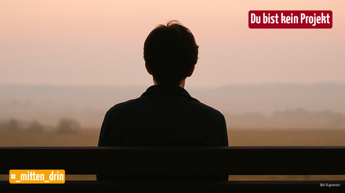 Mensch sitzt auf der Bank. Er blickt in die Ferne der Natur