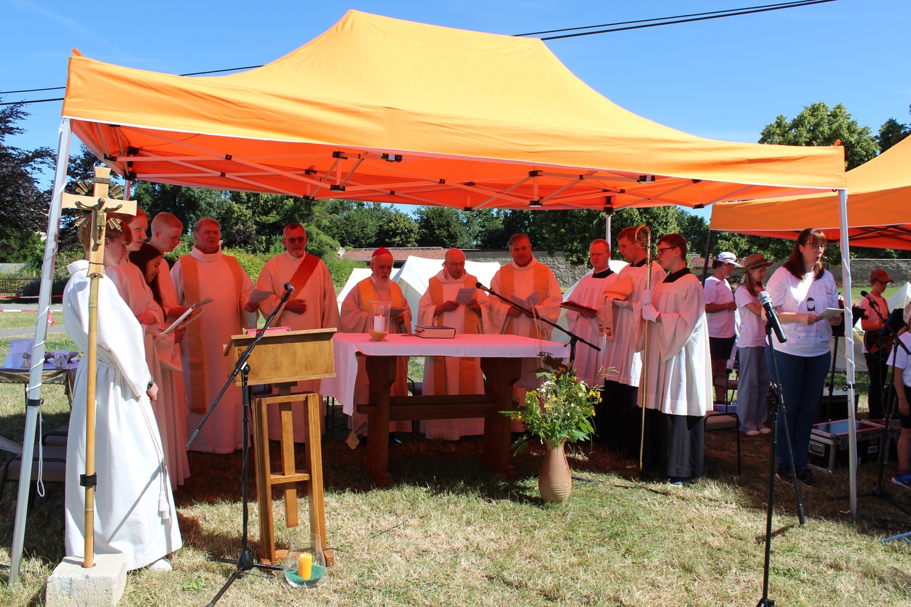 Ministranten und Priester um einen Tisch/Altar unter einem Pavillon