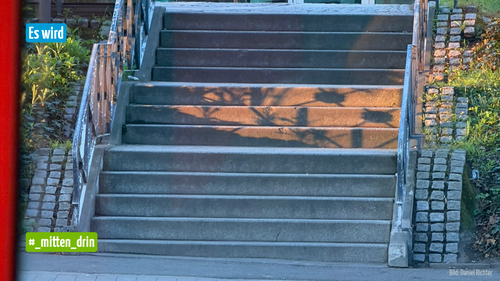 Treppenstufen, die teilweise im Sonnenlicht, teilweise im Schatten liegen.