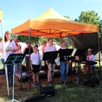Kinder und Jugendliche, die unter einem Pavillon singen und Instrumente spielen