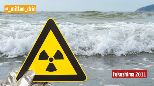 Es ist ein Meer zu sehen und eine Hand mit einem Schutzhandschuh, die ein Achtung Radioaktiv- Schild vor das Meer hält (gelbes Dreieck mit schwarzem Rand und Strahlen in der Mitte)